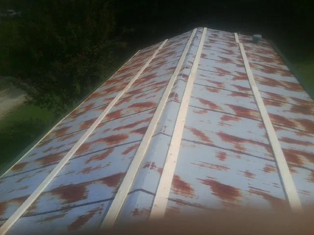 Rusted metal roof panels with new wood purlins before replacement — Storm Damage Roof Repair in Elizabethville by Roofing Brothers