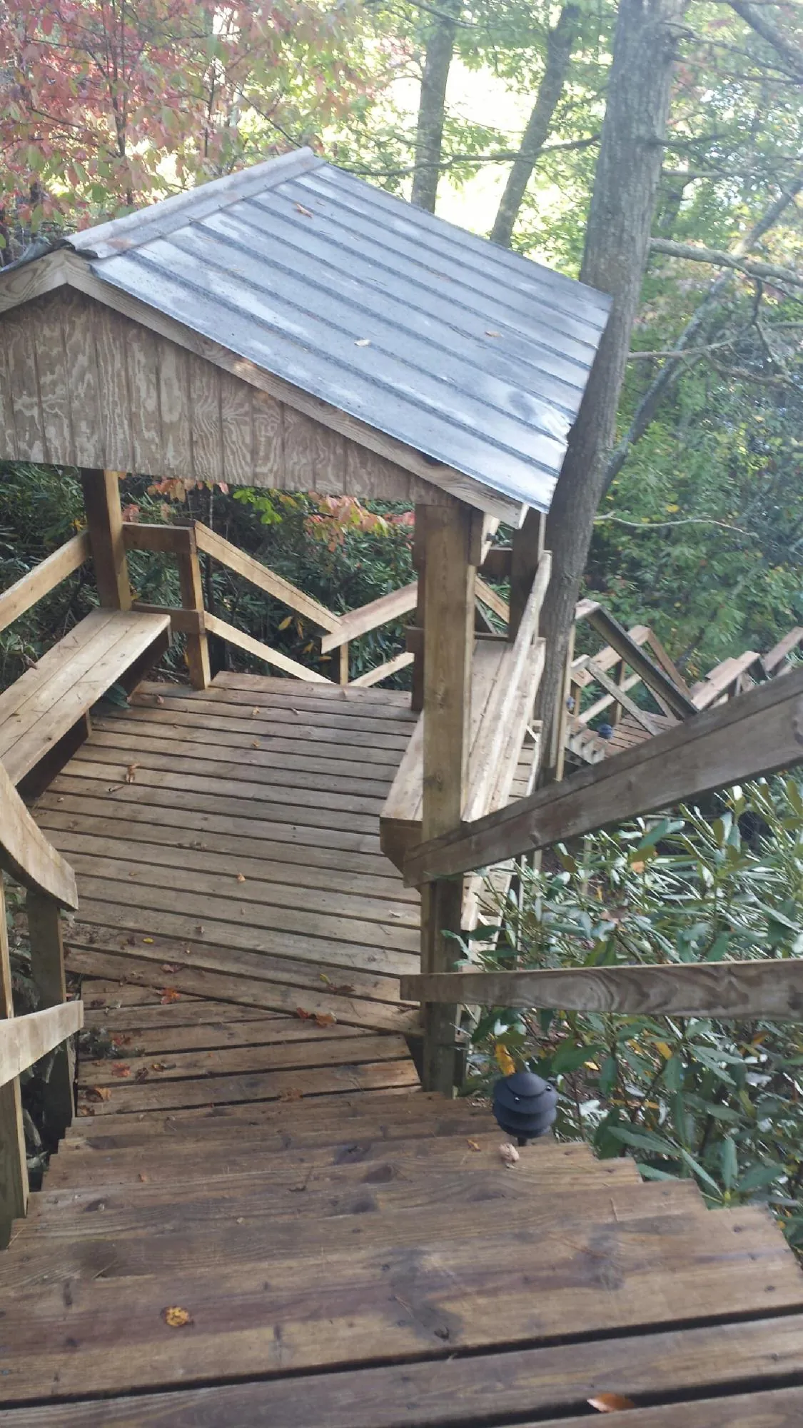 Metal roofed shelter over wooden steps on a wooded walkway — Skylight Repair & Installation work by our crew in Elizabethville